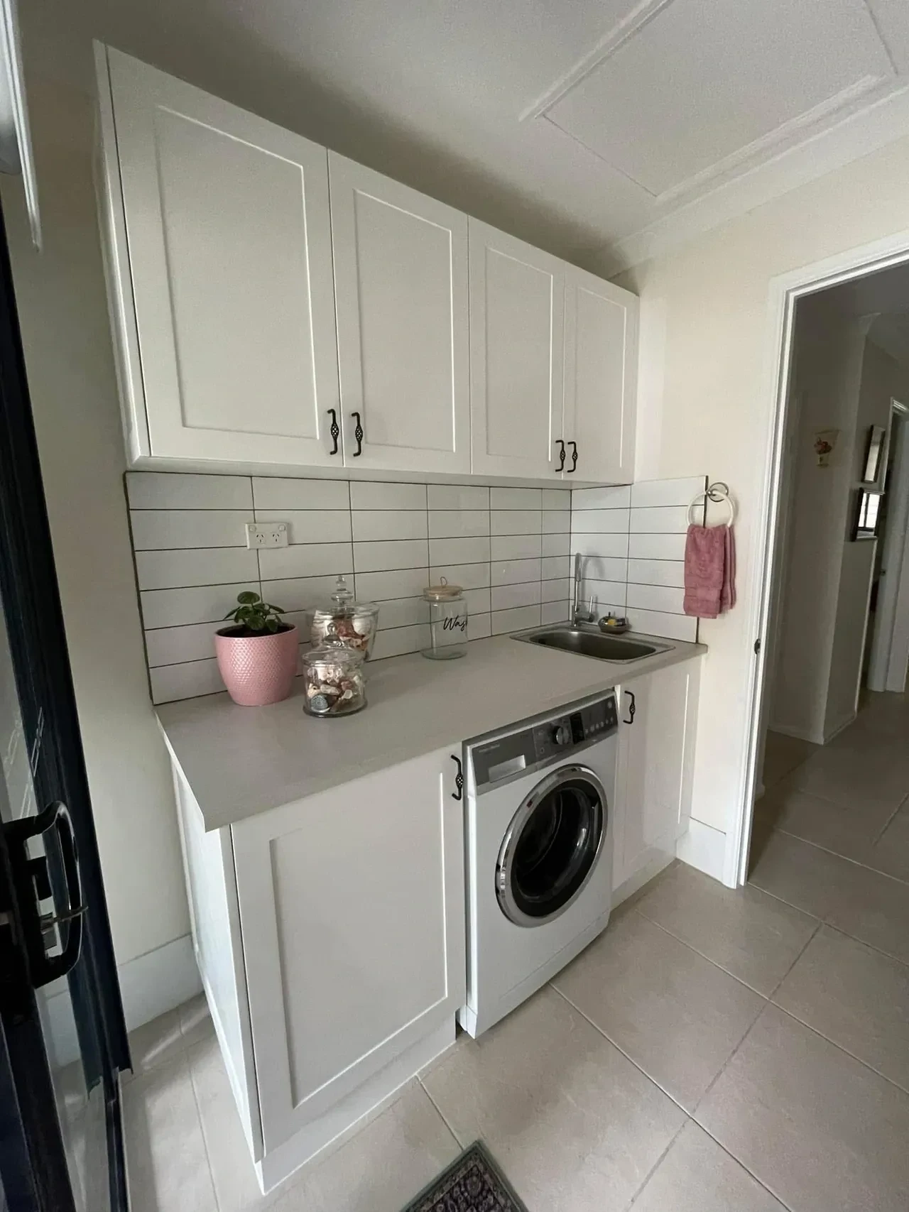 Custom white laundry cabinetry with subway tile splashback and integrated washing machine, Caloundra