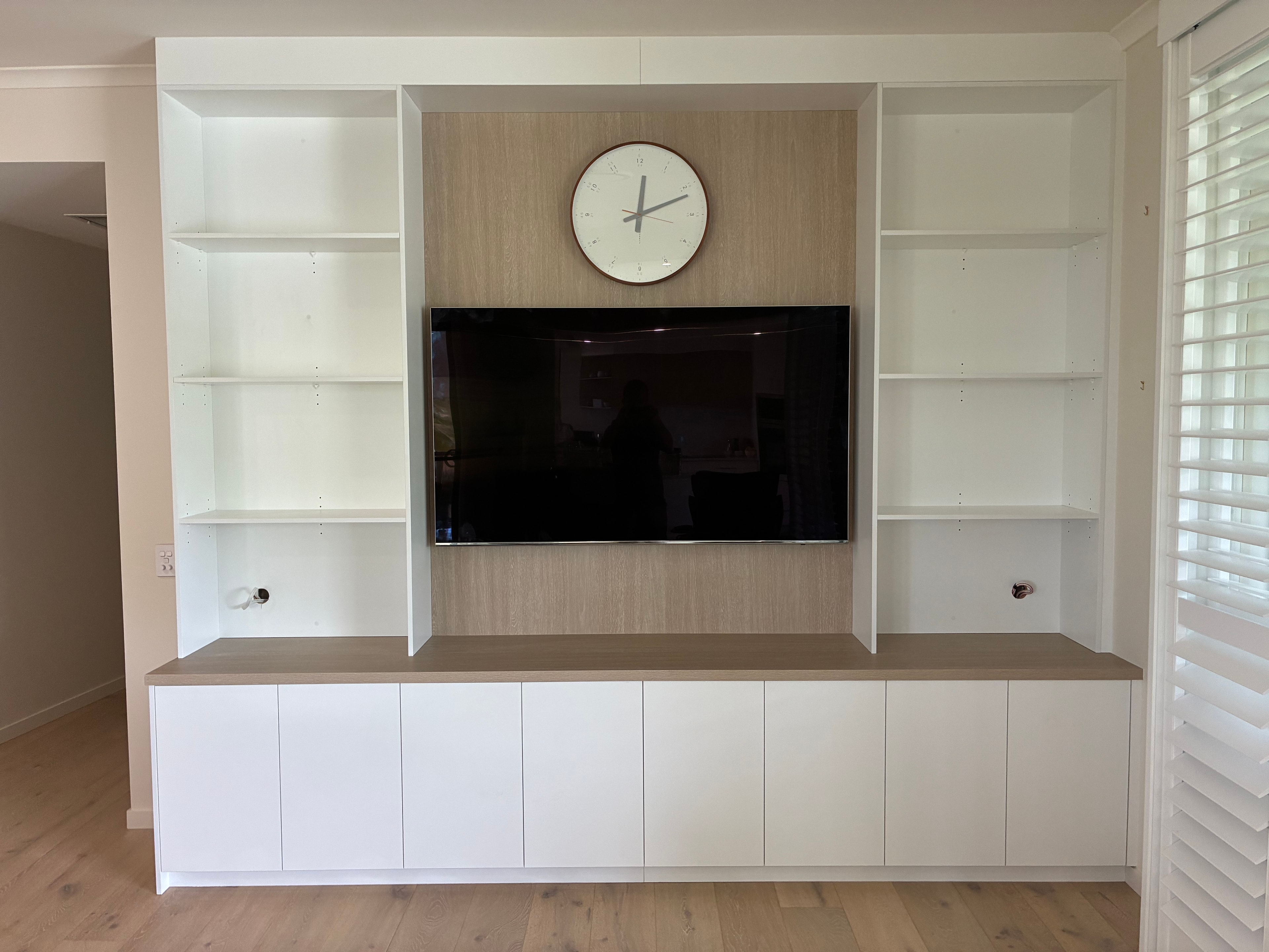 Custom built-in TV unit with white cabinetry, timber veneer backing and open shelving, Aroona